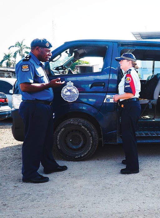 An officer from Papua New Guinea speaking with an AFP officer