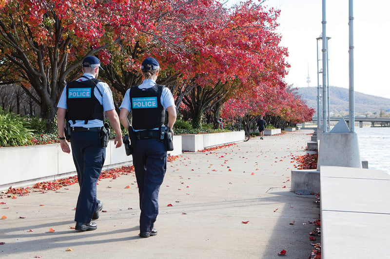 Two police officers walking along a footpath