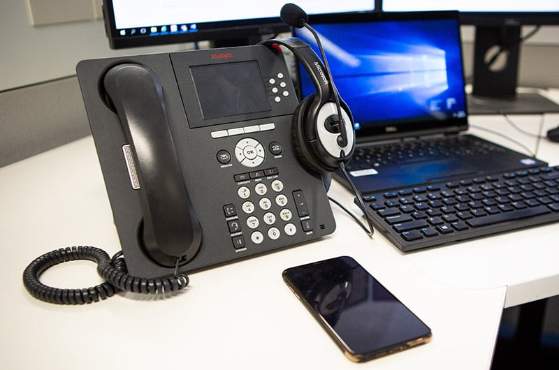 A desk phone, mobile phone and laptop computer
