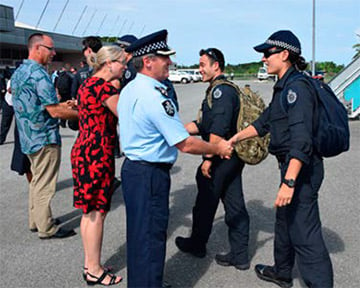 Internationally deployed AFP officers greeted by an AFP commander and two other representatives at an airport.