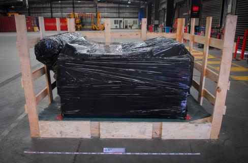 A large package wrapped in black plastic