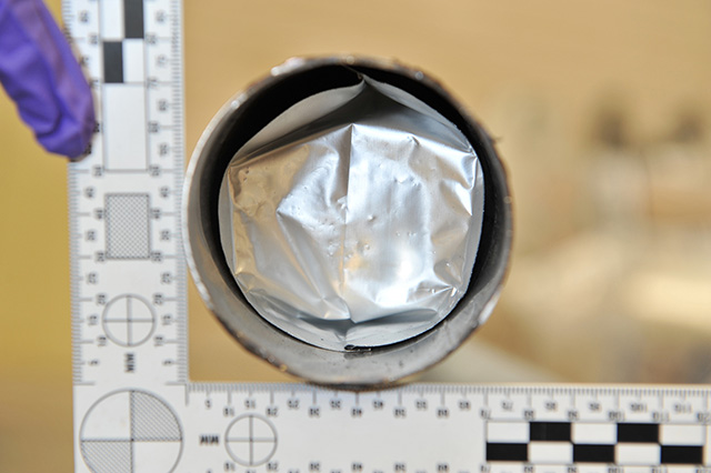 inside the metal stem of a stool containing a silver package containing crystal meth