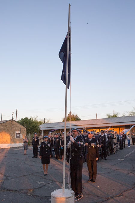 Sergeant Dale Cooper, who served in Cyprus in the 1990s and is a current AFP member, lowers the Australian National Flag in the United Nations Protected Area in Nicosia.