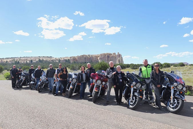 Road Captain Tony Toner and AFP Legatee Kefi Faupula with Red Team members outside the magnificent natural wonder of the El Morro National Monument in New Mexico