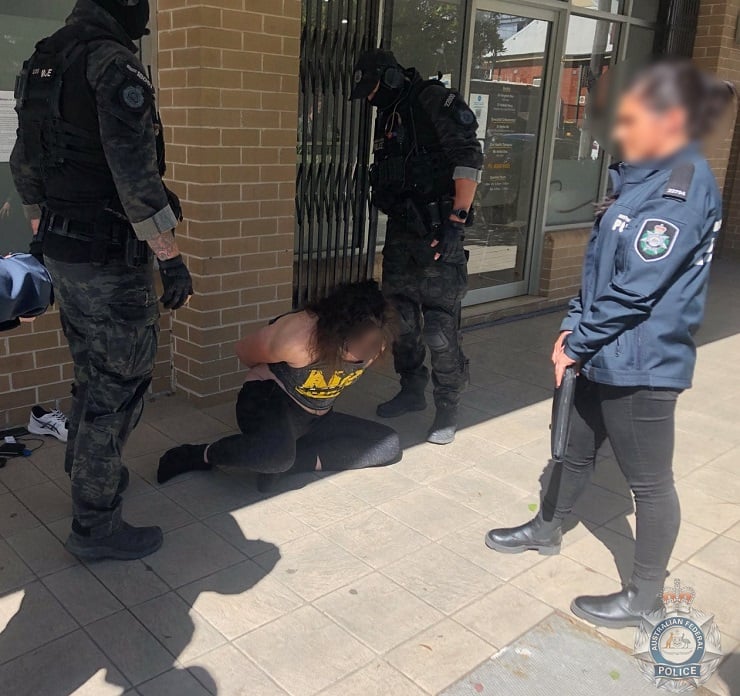 Offender handcuffed on the ground with two specialist police standing over him