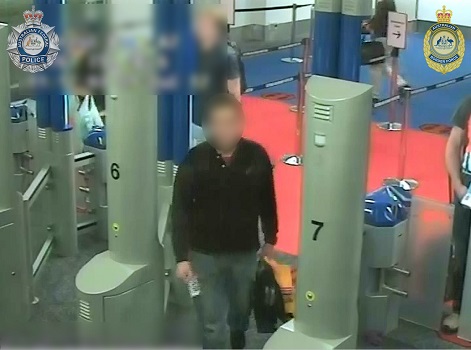 A man in grey pants and a black jumper is captured on CCTV at Sydney Airport