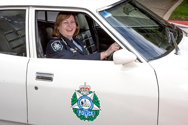 AFP Deputy Commissioner Leanne Close takes a seat in the AFP's 1974 XB Falcon patrol car after the launch at the National Museum of Australia