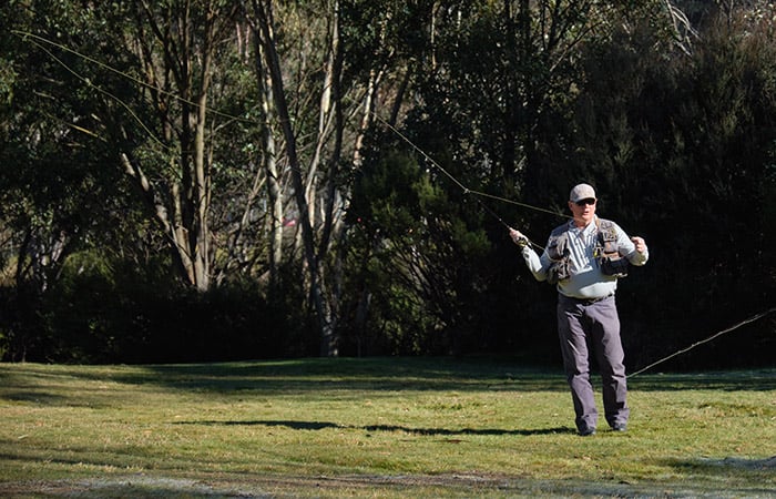 A man practice casting a fly fishing rod