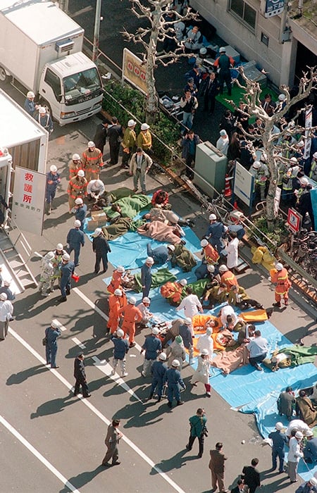 Multiple people laying on a street being attended to by emergency services