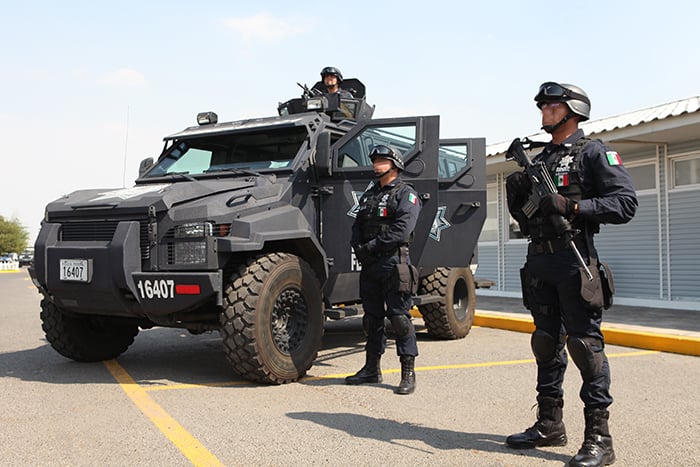 Three tactical response officers with a large tactical vehicle