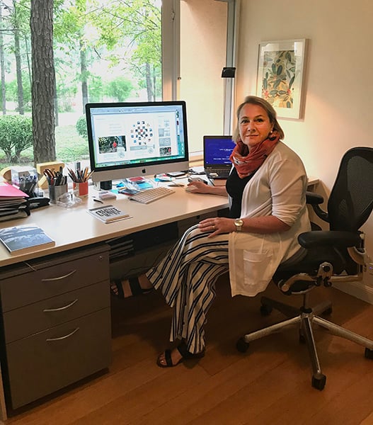 A female sitting in a home office in front of a computer