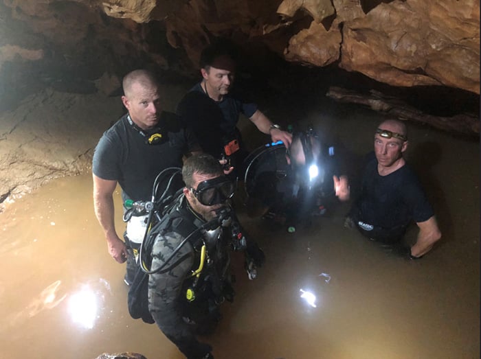 Five male divers, with two ready to go under water