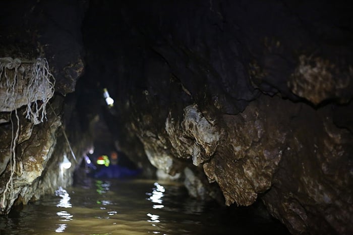A narrow section in the cave with high level of brown muddy water