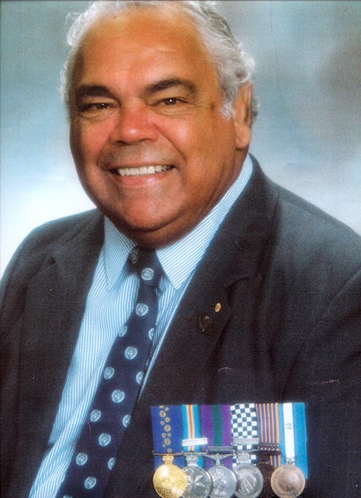 A man in a suit wearing six medals