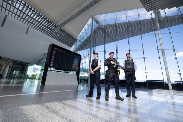 Three uniformed and armed police officers patrolling Canberra Airport