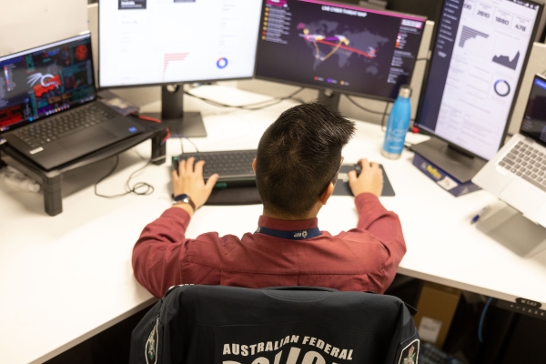 AFP member at a work desk with six screens processing information