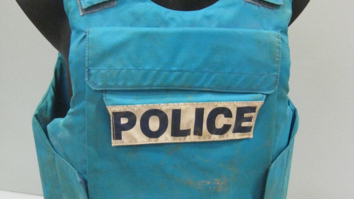 Blue woven fabric padded vest with front pocket and large white label that reads 'POLICE' in large black block letters (AFPM8869)