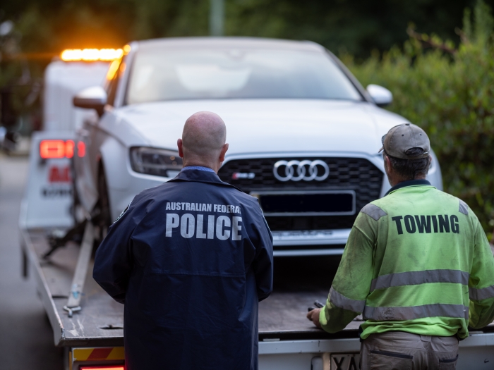 Police officer and tow truck operator confiscating a vehicle