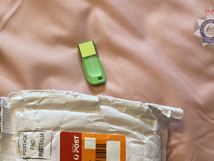 Seized green USB on bedsheet