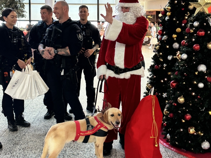 Santa with a Canine and Police at an Airport
