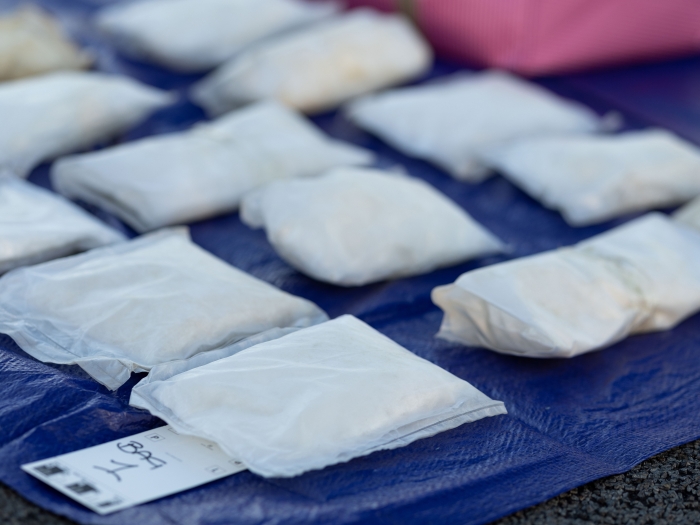 Bags of methamphetamine are laid out on a blue tarp.