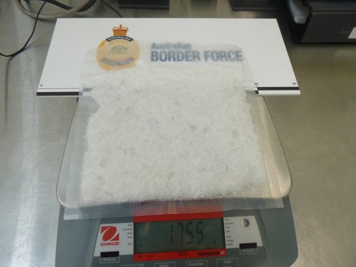 A sealed bag of a white crystalline substance sits on a set of scales.