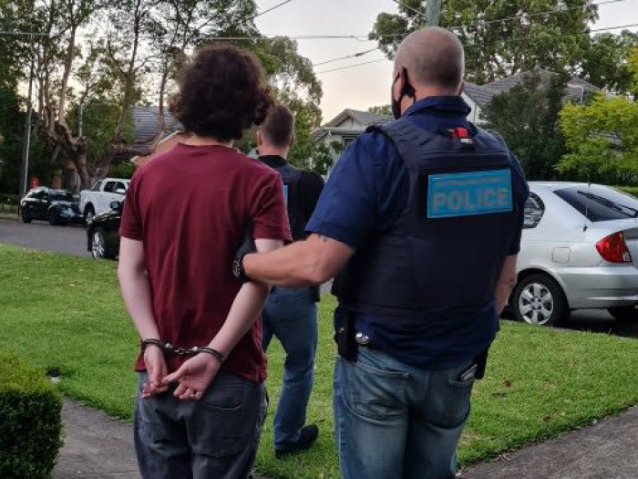 man in handcuffs with AFP officer holding him