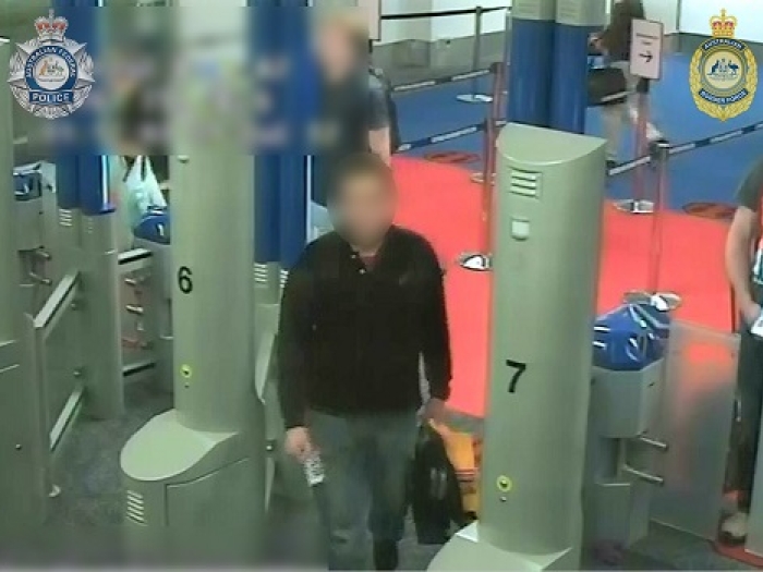 A man in grey pants and a black jumper is captured on CCTV at Sydney Airport