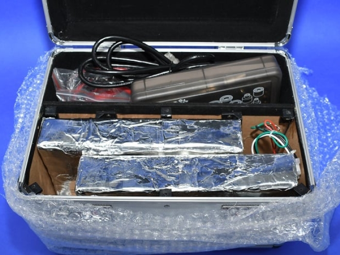 Two foil wrapped blocks of cocaine are hidden in a false cavity in a silver box.