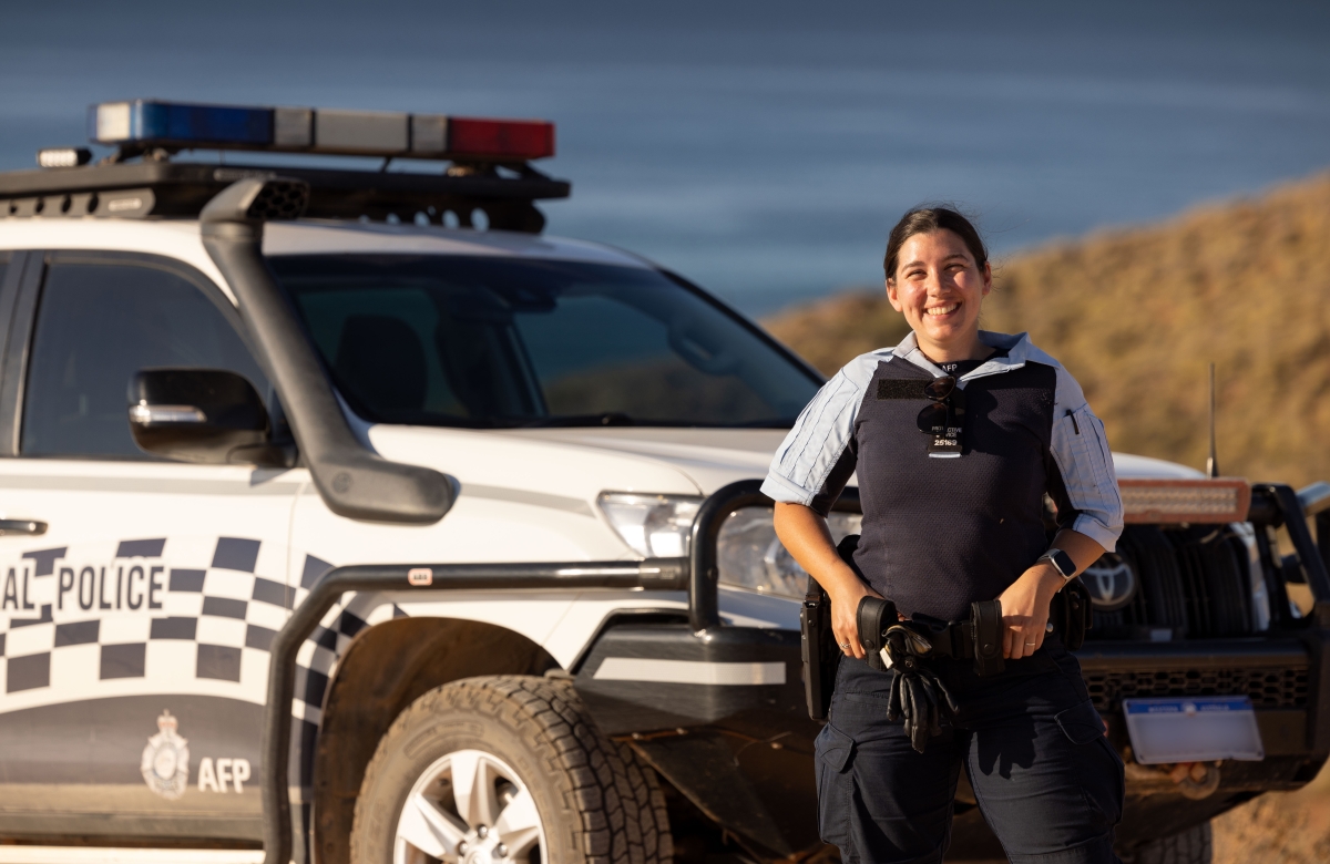 AFP Protective Service Officer in front of a car parked in Exmouth