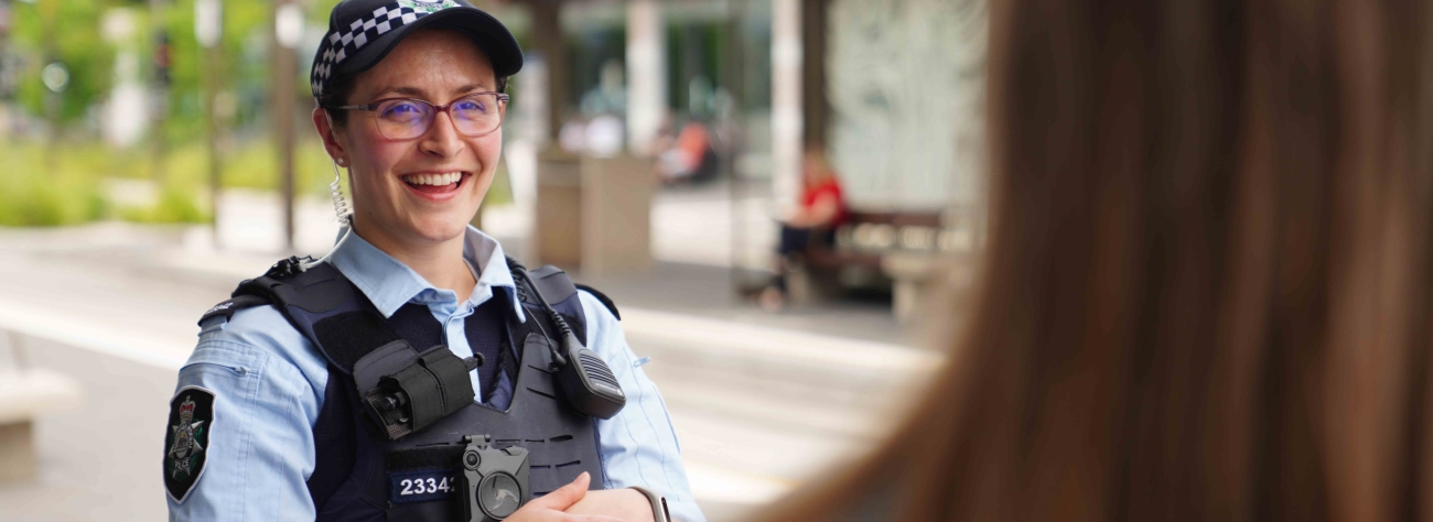 ACT Police officer smiling while talking to a member of the public