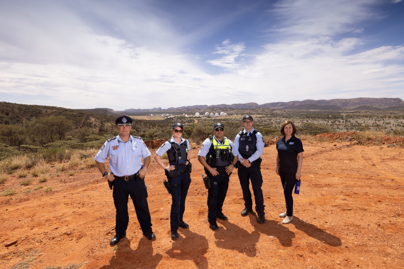 Five AFP Protective Service Officers on red dirt in Central Australia