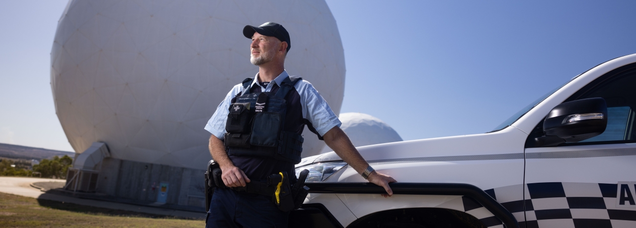 Protective Service Officer patrolling a communications station in front of AFP vehicle