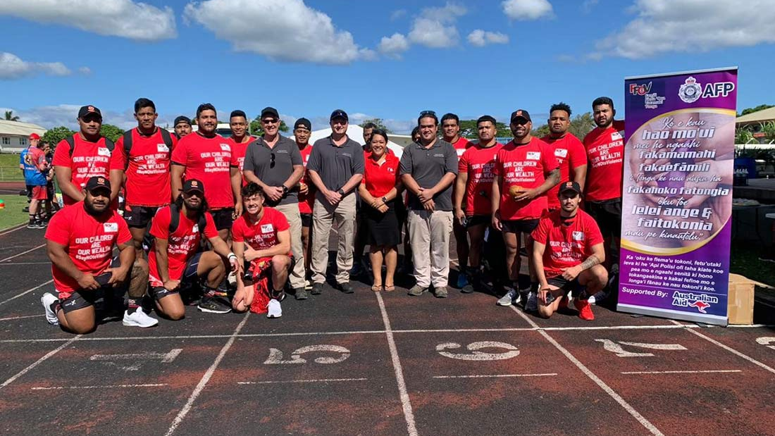 Tonga rugby union members with Families Free of Violence staff members. Rugby union planers are wearing FFOV shirts with the caption 'Our Children Are our Wealth #Say NO to Violence'