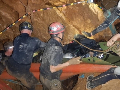 A member of the Wild Boars soccer team on a flexible stretcher is moved through one of the last three chambers of the Tham Luang Nang Non cave system.