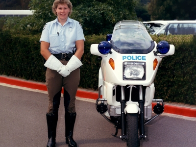 Sergeant Louise Denley in 1989, standing next to her police motorcycle – black boots, white gloves, riding jodhpurs (AFPMRN441)
